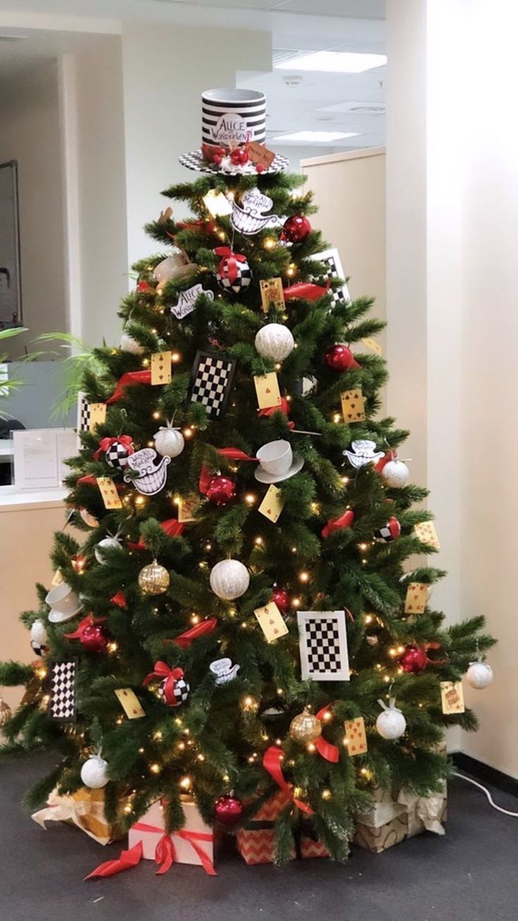 a decorated christmas tree in an office cubicle with black and white checkered ribbon