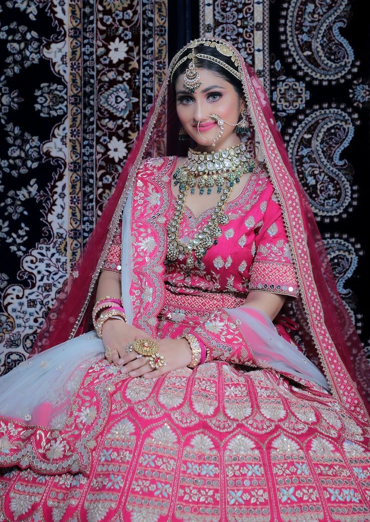 a woman in a pink and gold bridal outfit