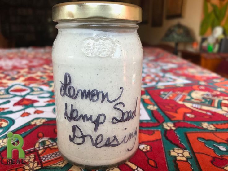 a jar with writing on it sitting on top of a colorful tablecloth covered floor