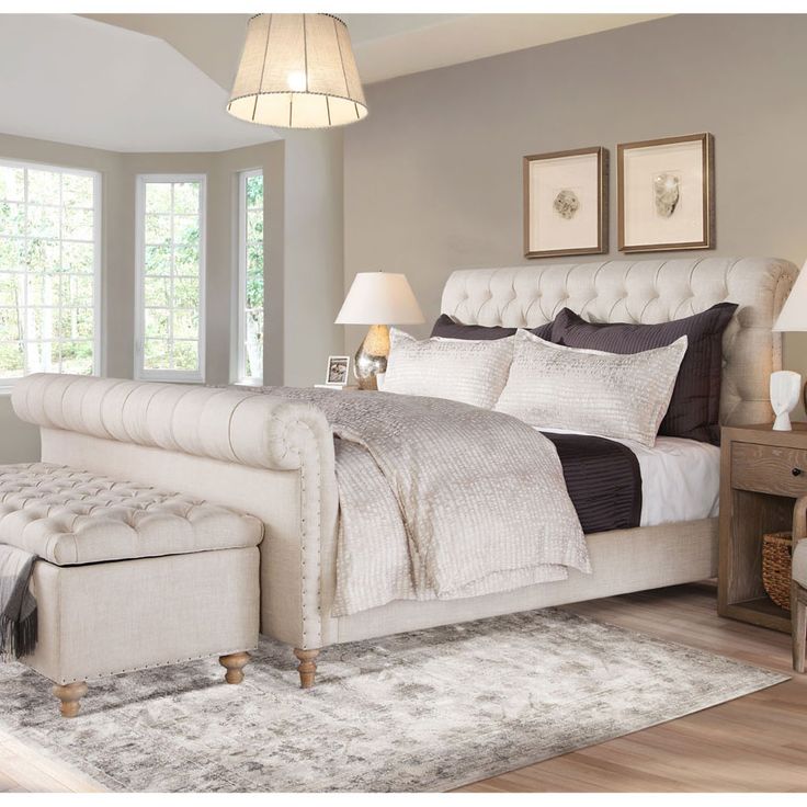 a large white bed sitting in a bedroom next to two lamps on either side of the bed