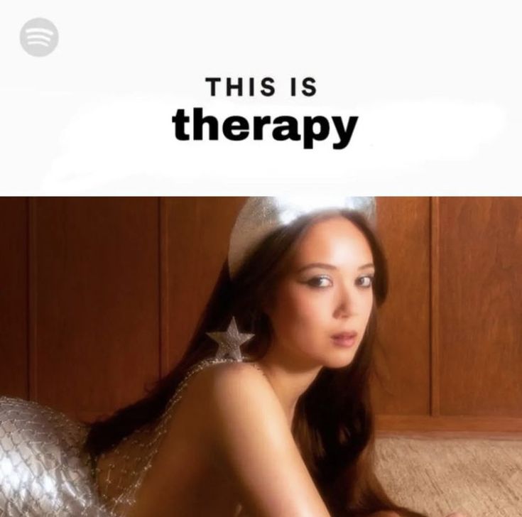 a woman laying on top of a bed next to a wooden wall with the caption'this is therapy '