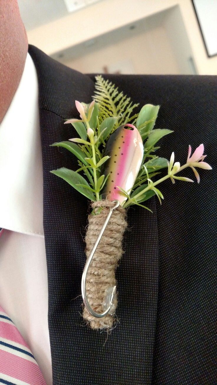 a man wearing a suit and tie holding a flower in his lapel pin,