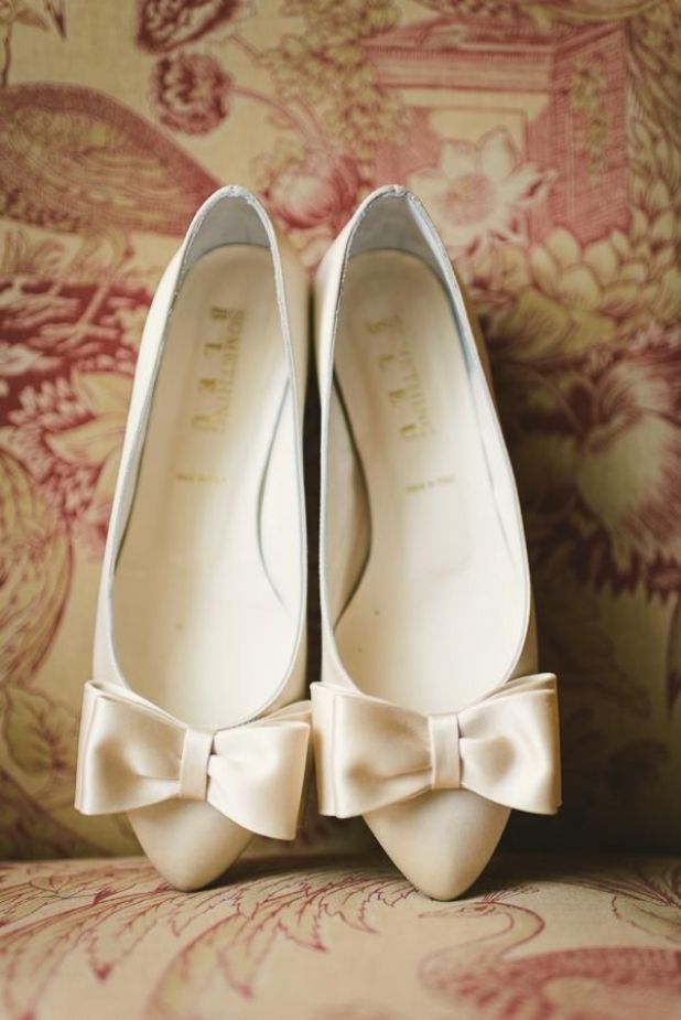 a pair of white shoes with bows on them