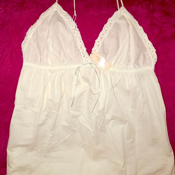 Cotton White With Embroidered Trim Of White Lace With Baby Blue Ribbon And Straps White Cotton V-neck Sleepwear, Feminine V-neck Top For Bedtime, Feminine Cotton Camisole For Vacation, Feminine Cotton Bedtime Tops, Feminine Cotton Camisole For Beach, Summer Cream Sleepwear With Lace Trim, Cotton V-neck Top For Bedtime, Feminine White Lace Trim Camisole, Cream Lace Trim Summer Sleepwear