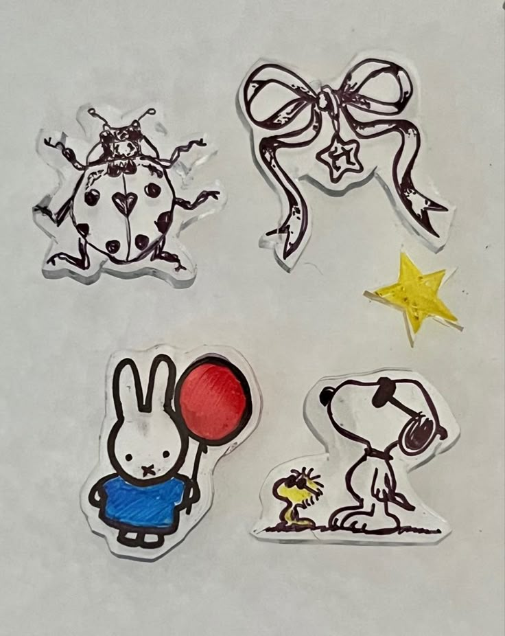 four stickers with different designs on them, one has a dog and the other has a balloon