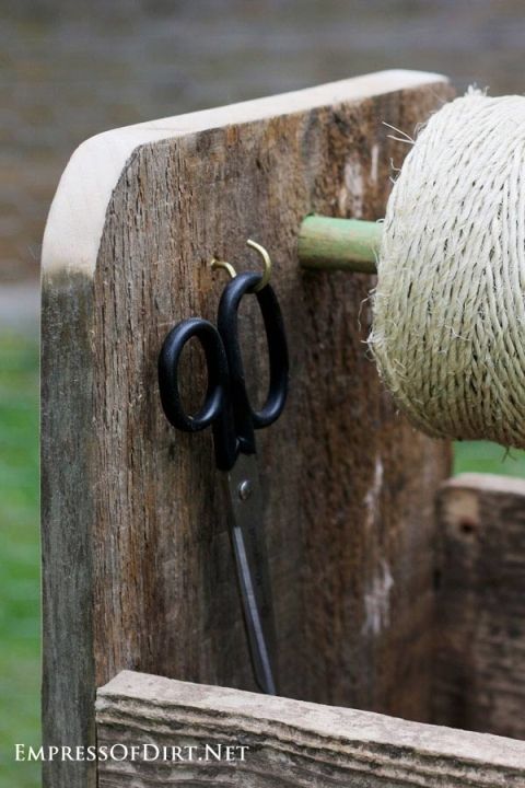 a pair of scissors is hooked up to a piece of rope on a wooden box