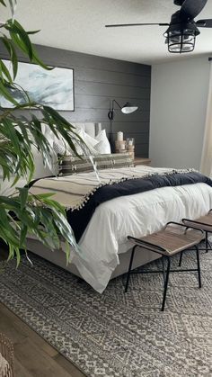 a bedroom with a bed, two chairs and a painting on the wall above it