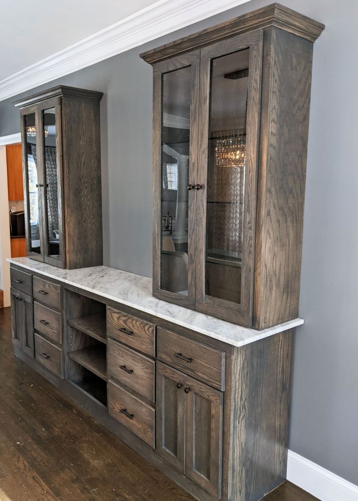 a large wooden cabinet with marble top and drawers