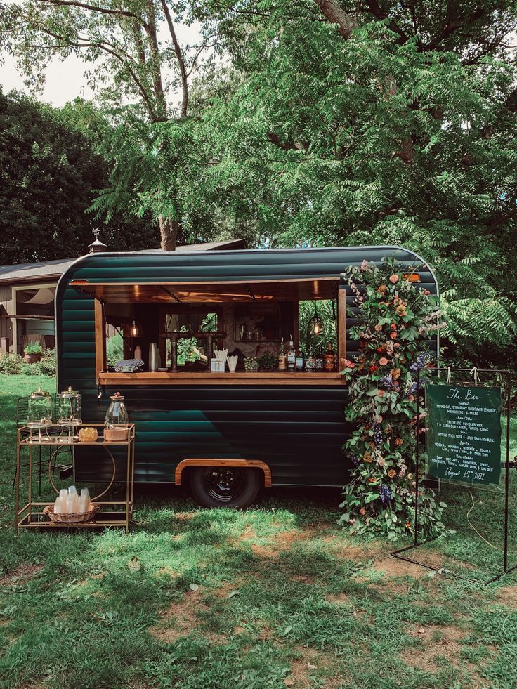 an old camper converted into a mobile bar with plants growing on the side and outside