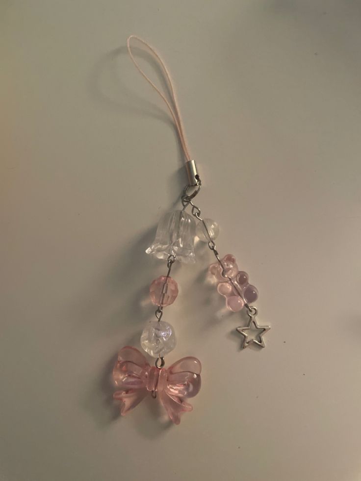 a pair of pink and clear glass beads hanging from a silver metal keychain