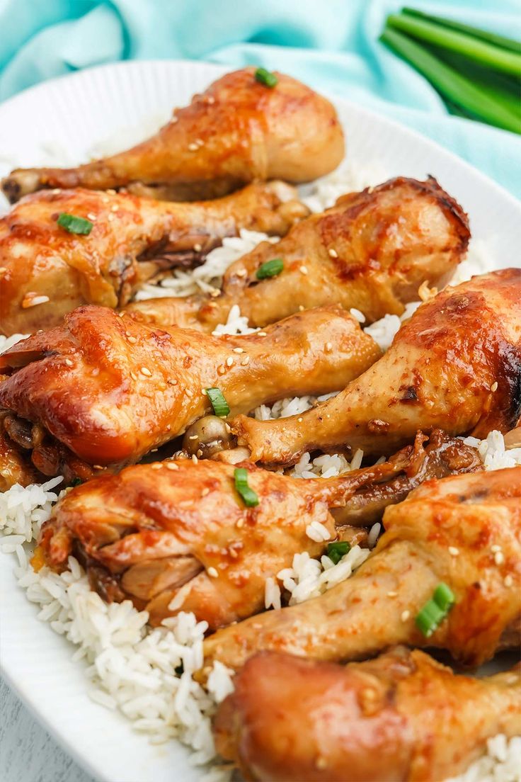 chicken wings with rice and green onions on a plate