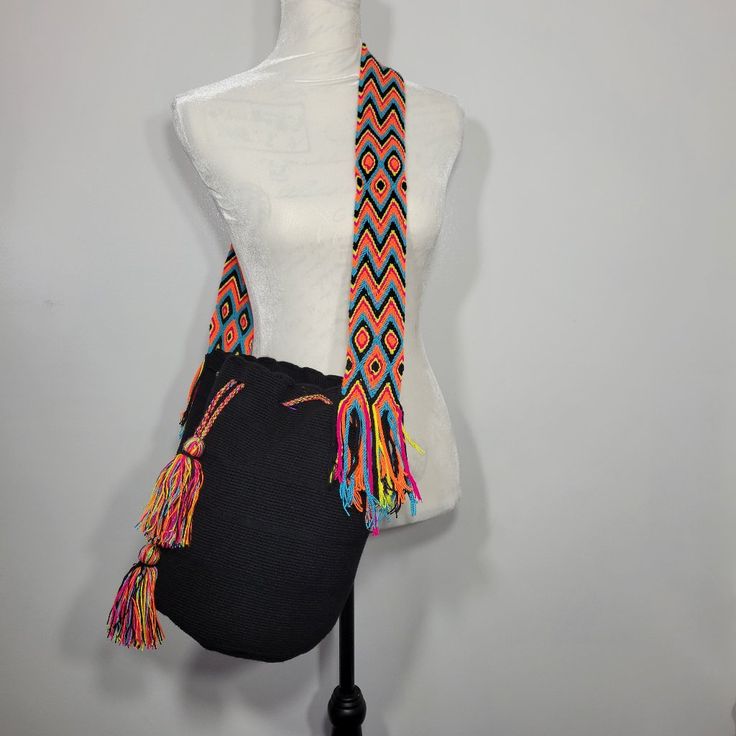 100% Handwoven By The Artisans Of The Colombian Wayuu Tribe Crossbody Bucket Bag; Strap Can Be Knotted For Shoulder Bag Style. Drawstring Closure, With Tassels With Side Fringe Color: Black With Multi Color Fringe And Strap With Orange, Teal, Black, Pink, Yellow Material: Acrylic Approximate Bag Dimensions: Length 11.5" Height 11.25" Strap Drop 19" **(Each Bag Is Unique And Can Vary By 1 Inch Or So.)** All Wayuu Bags Are Handmade, Unique In Color & Design Black Woven Pouch Shoulder Bag, Black Woven Crossbody Bucket Bag, Black Adjustable Crossbody Shoulder Bag, Adjustable Black Crossbody Shoulder Bag, Black Shoulder Bag With Removable Pouch, Black Shoulder Bag With Removable Pouch And Adjustable Strap, Black Shoulder Bag With Removable Pouch For Festival, Black Adjustable Crossbody Bag, Black Crochet Crossbody Bag For Beach