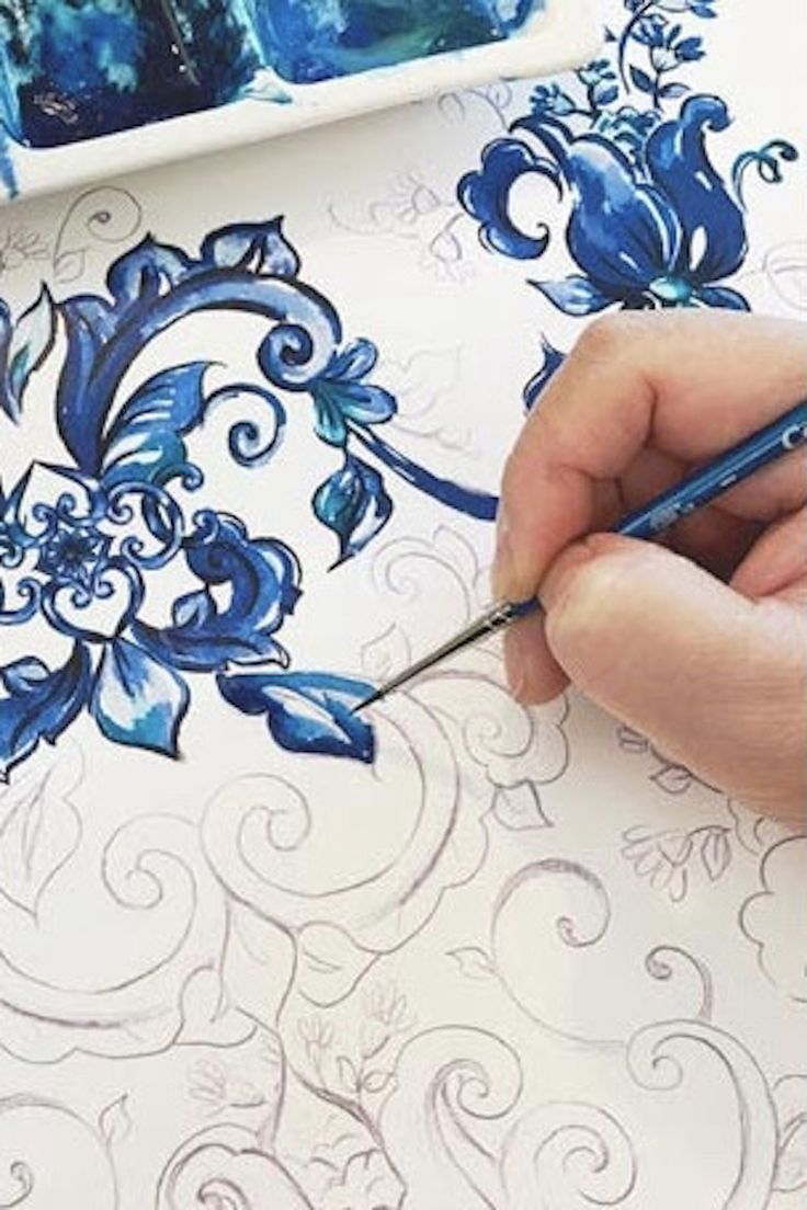 someone is drawing on paper with blue ink