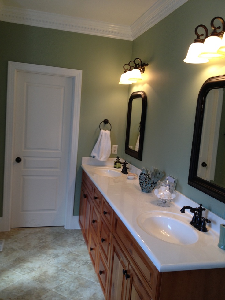 a bathroom with two sinks, mirrors and lights on the wall next to each other