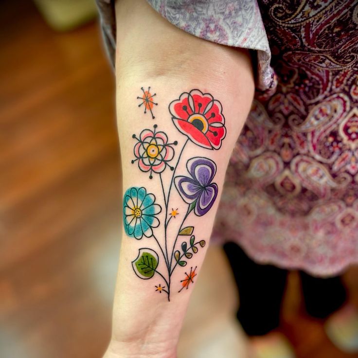 a colorful flower tattoo on the left arm