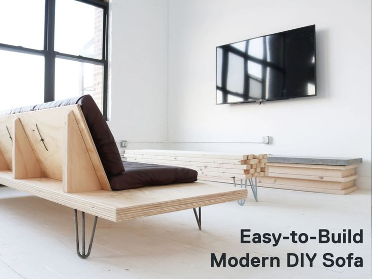 a wooden bench sitting in the middle of a living room next to a large window