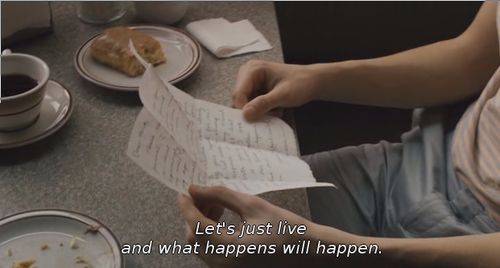 a person sitting at a table with food on it and a book in front of them