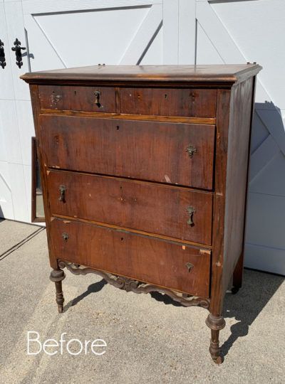 an old wooden dresser sitting in front of a garage door