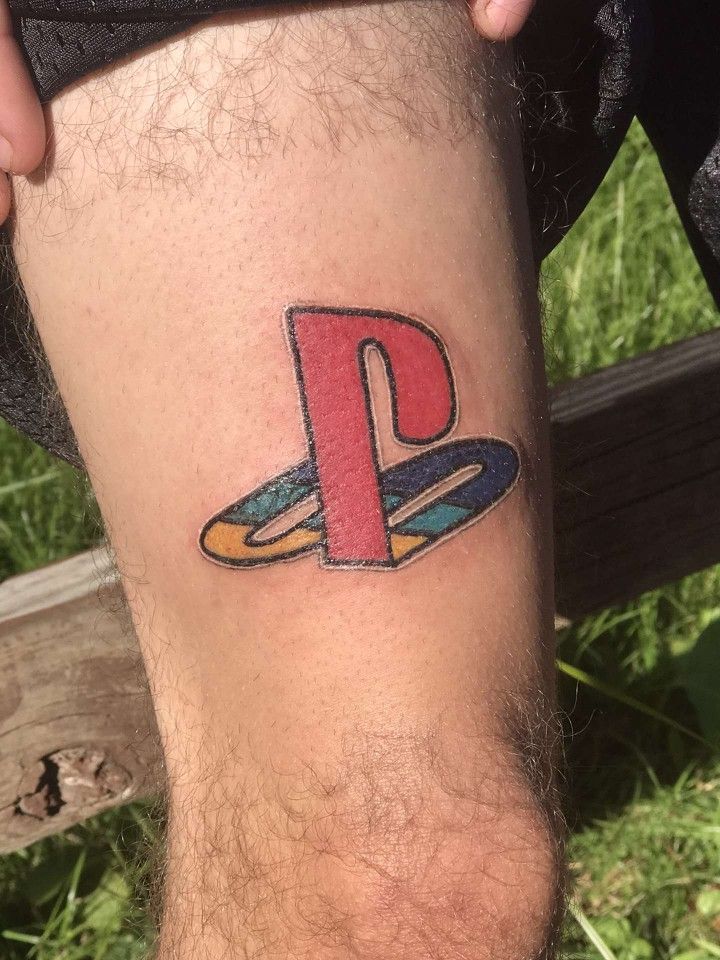 a man's leg with a tattoo on it that has the letter p painted on it