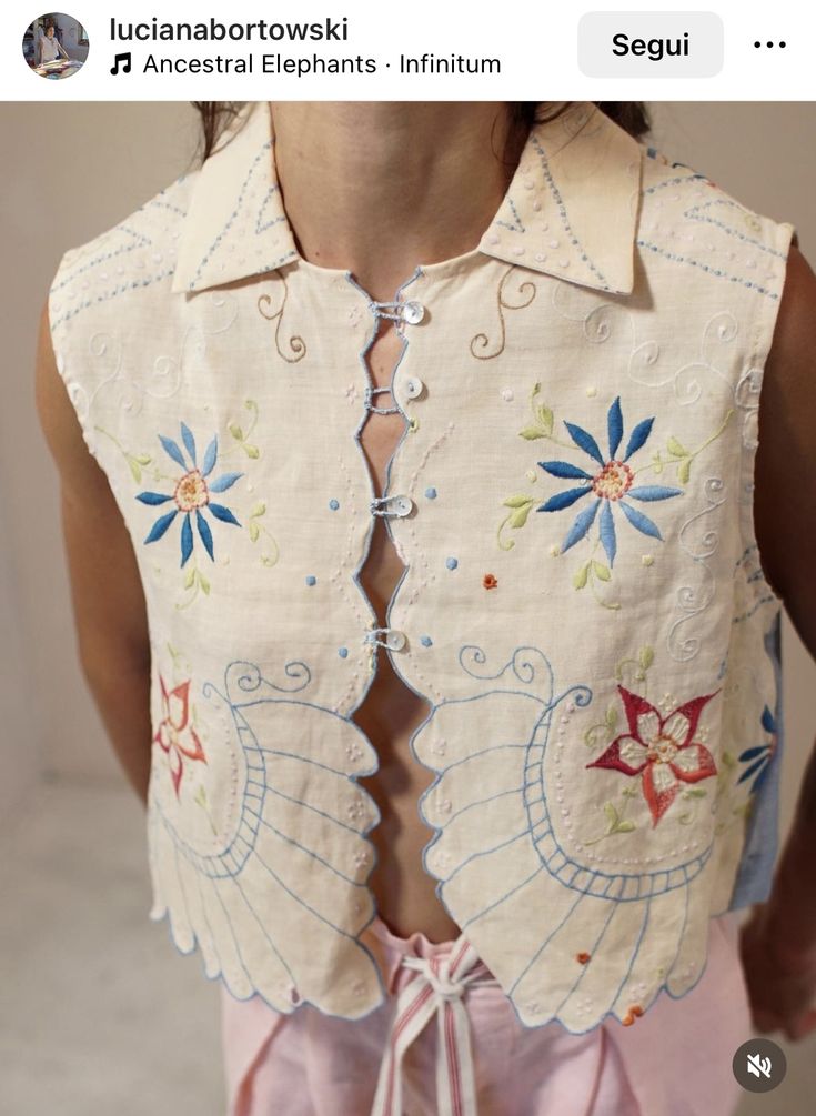 the back of a woman's shirt with an embroidered design on it and pink pants