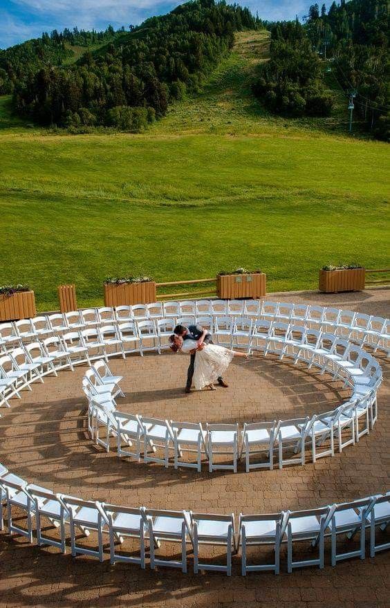 an aerial view of a newly married couple standing in the middle of a circular seating area