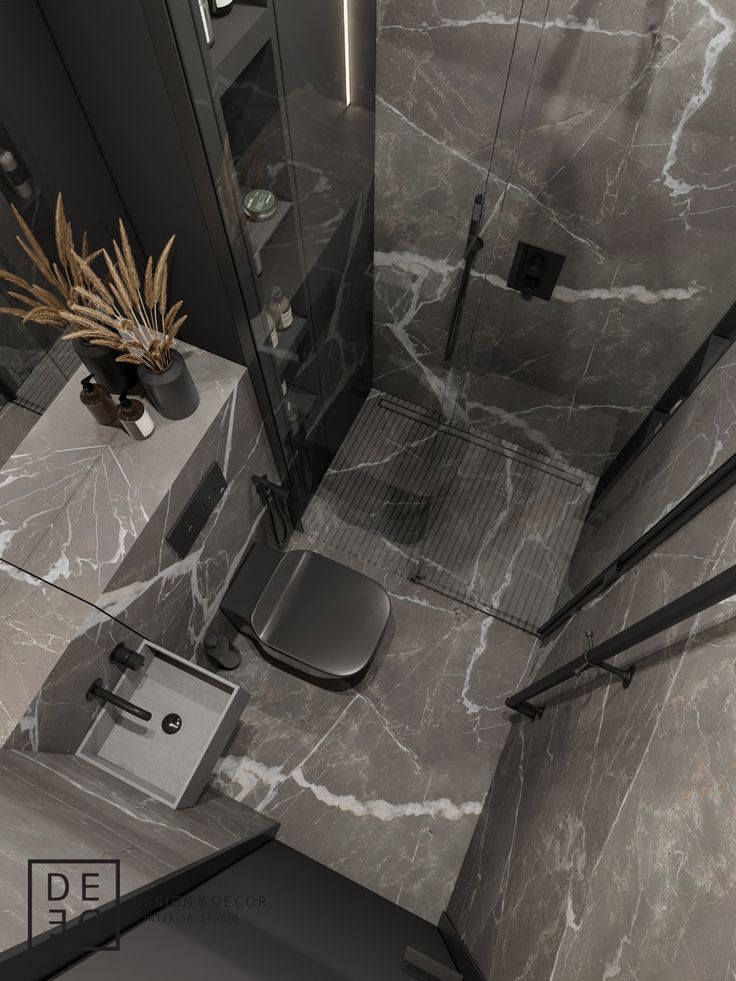 a modern bathroom with grey marble walls and flooring, including a shower stall area