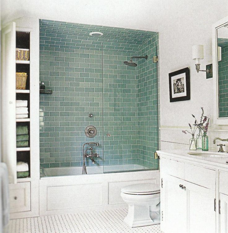 a bathroom with green tiles and white fixtures