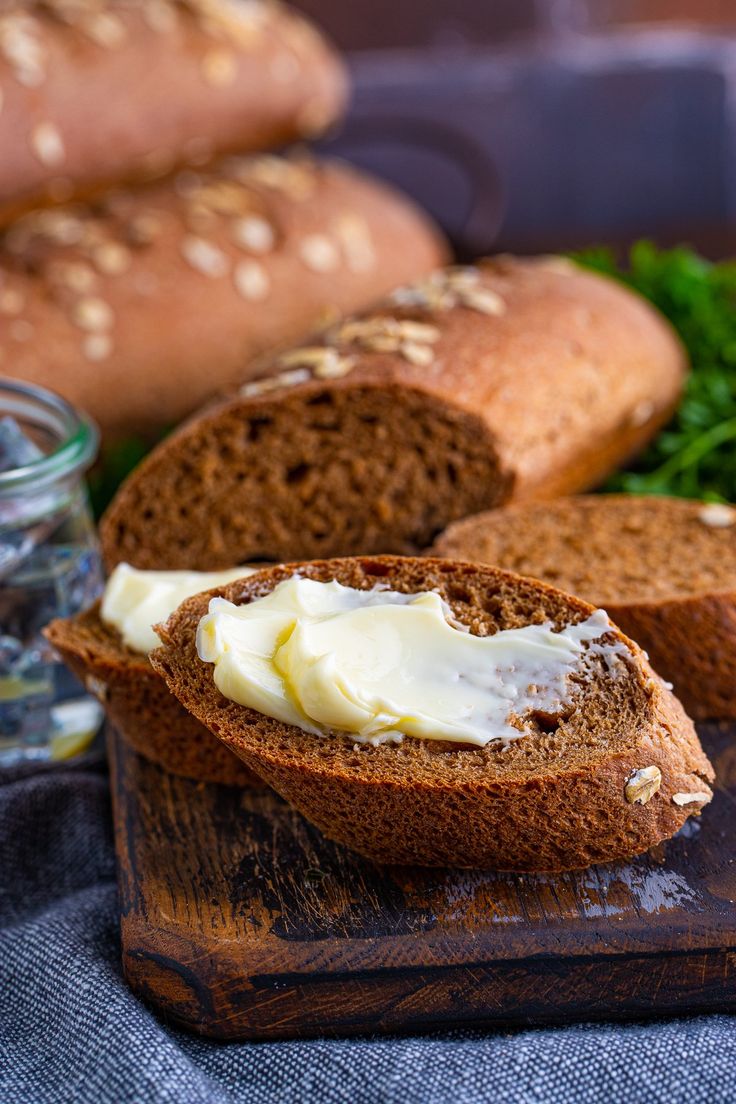 bread with butter and parsley on a wooden cutting board next to other breads