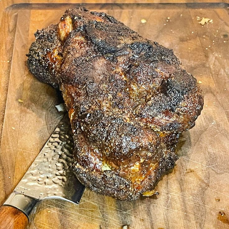 a steak on a cutting board with a knife