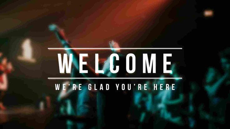 people are standing in front of a stage with their hands up and the words welcome