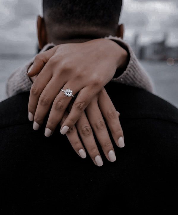 a man and woman holding each other close to one another with their hands on his shoulder