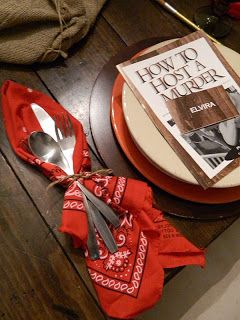 a table topped with a plate covered in silverware next to a book and spoon