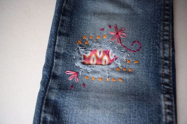 a pair of jeans with embroidered designs on them