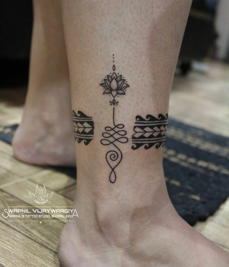 a woman's foot with a tattoo design on the side of her leg and ankle