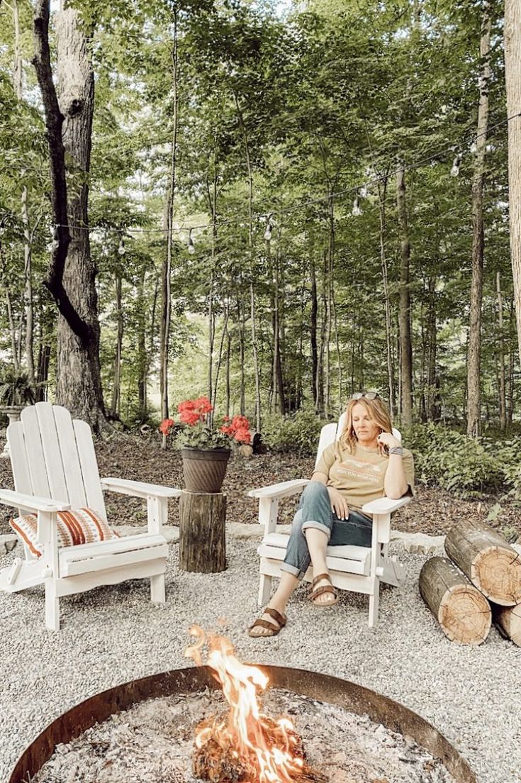 a woman sitting in a chair next to a fire pit