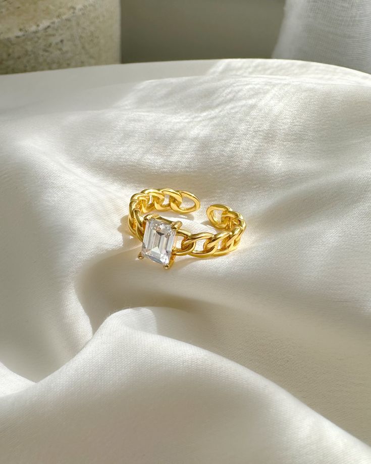 Une bague chaîne conçue avec une pierre de zircone au centre. Cette pièce élégante et intemporelle est la bague de promesse ou le cadeau parfait pour un être cher. Avec son design classique et ses matériaux luxueux, la chaîne en cristal RING ne manquera pas de faire sensation.

 Taille : bague réglable en zircone cubique de 4,8 mm.

 Matière : Argent massif plaqué or 18 carats

 résistant à l'eau, hypoallergénique et sans nickel



 emballé dans une boîte à bijoux à tiroir ILLÁRI Drawer Jewelry, Silver Water, Crystal Chain, Chain Ring, Gold Plated Sterling Silver, Adjustable Rings, Promise Rings, Timeless Pieces, Ring Designs