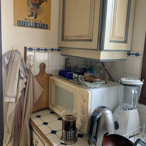 a kitchen with a microwave, toaster oven and coffee pot on the counter top