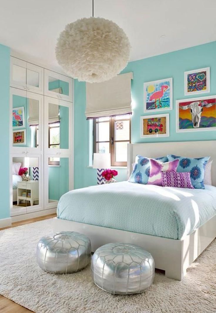 a bedroom with blue walls and pictures on the wall