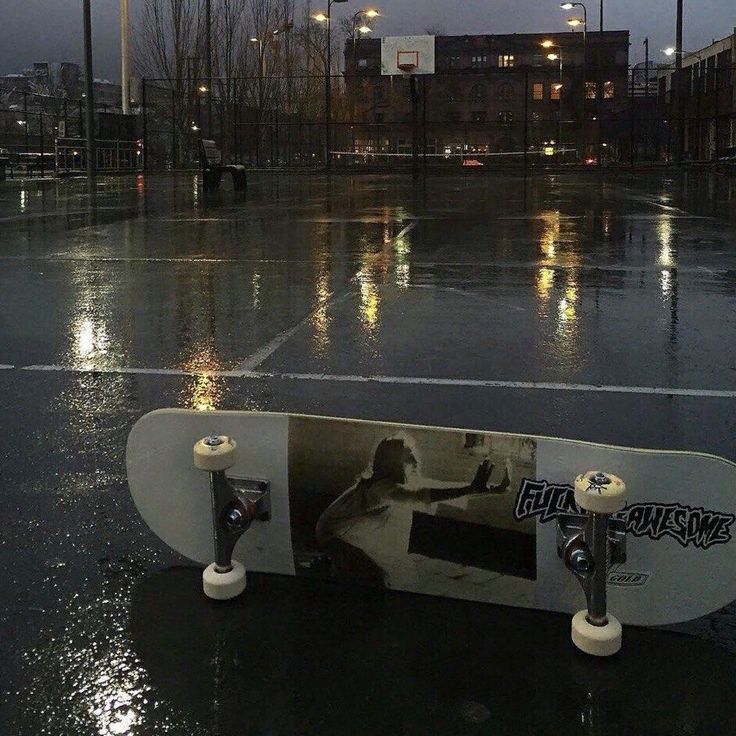 a skateboard sitting on top of a wet parking lot