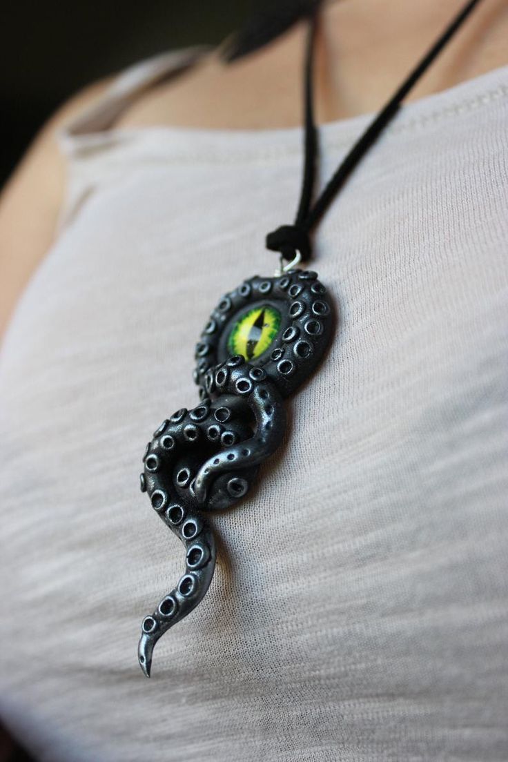 a woman wearing a necklace with an octopus on it's face and yellow eyes