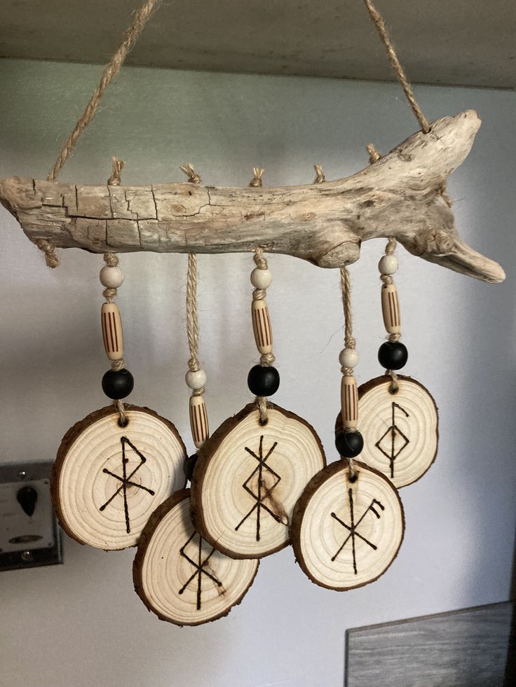 four wooden ornaments hanging from a tree branch