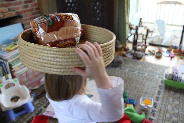 a young child holding up a basket with chocolates in it