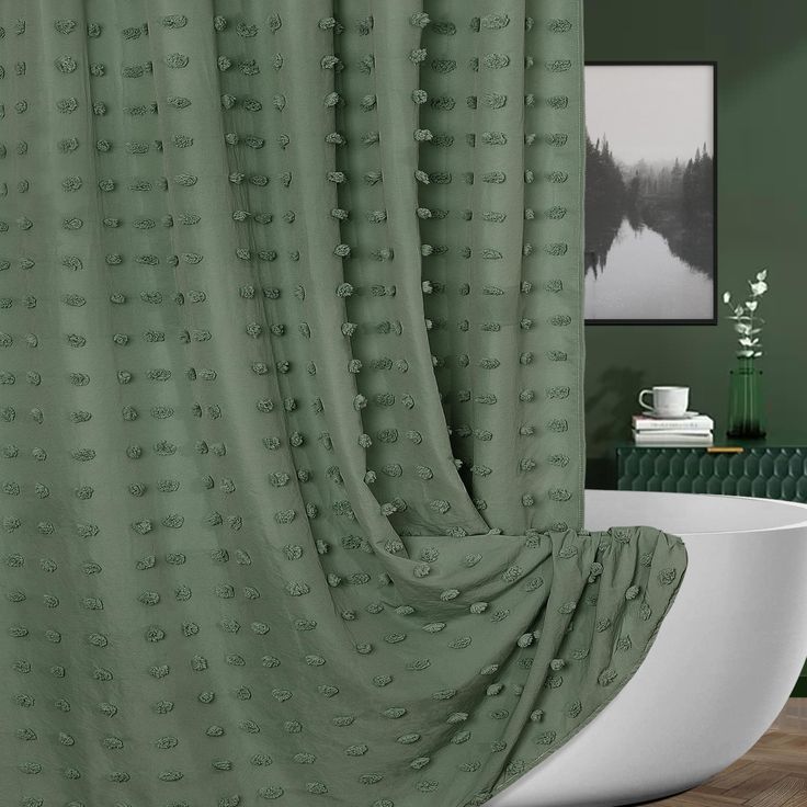 a bath tub sitting next to a shower curtain in a bathroom with green walls and wooden floors