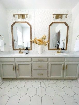 a bathroom with two sinks, mirrors and tiled flooring in the middle of it