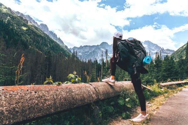 a person with a backpack is standing on a log