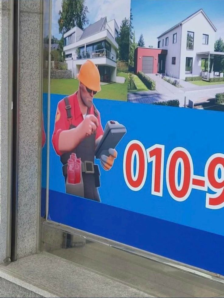 a man in an orange safety helmet is using a machine on the side of a building