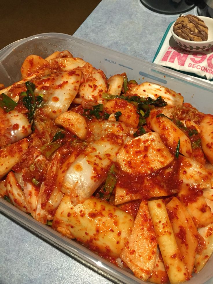 a plastic container filled with pasta and sauce