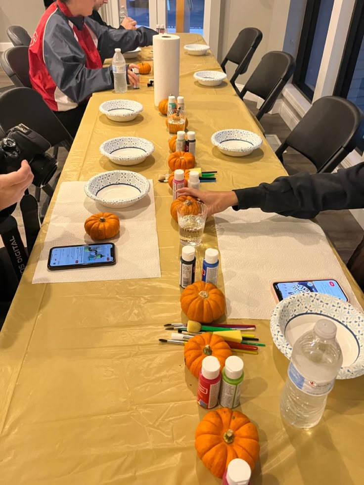 two children sitting at a table with pumpkins on it