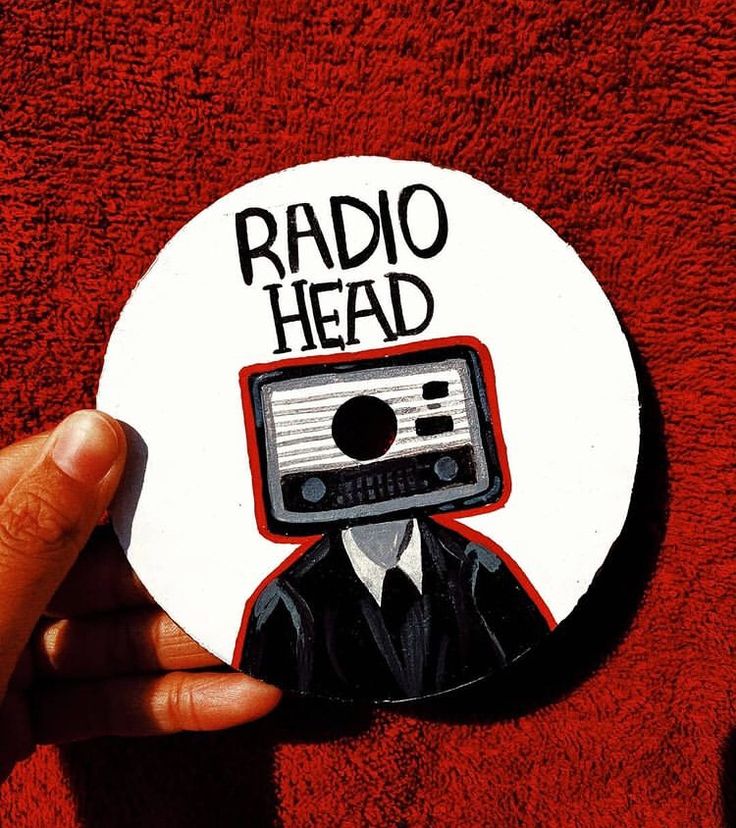 a person holding up a radio head sticker