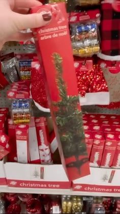 a person is holding up a christmas tree in front of some candy canes and other items